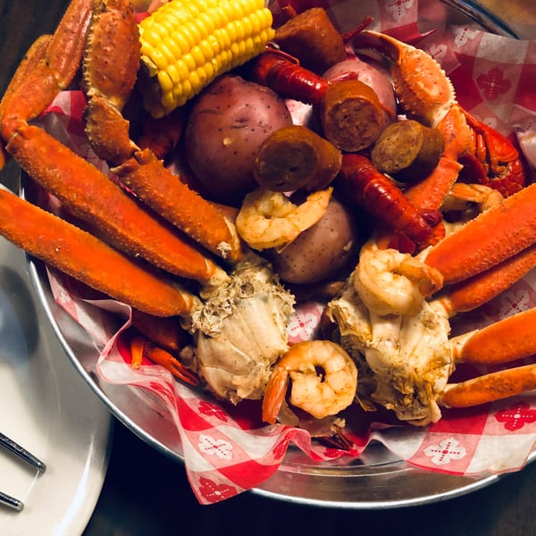 Captain John's seafood boil with crab legs, shrimp, crawfish, corn, potatoes, and sausage.