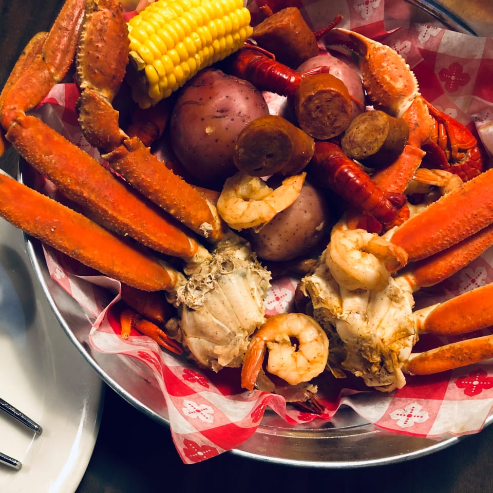 Captain John's seafood boil with crab legs, shrimp, crawfish, corn, potatoes, and sausage.